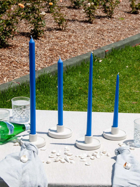 Capri blue Moreton taper candles on outdoor table setting.