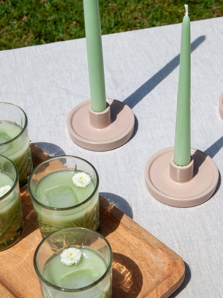 Moreton 25cm Matcha Taper Candle, eco-friendly, handmade, clean burning, on rustic table setting with drinks.