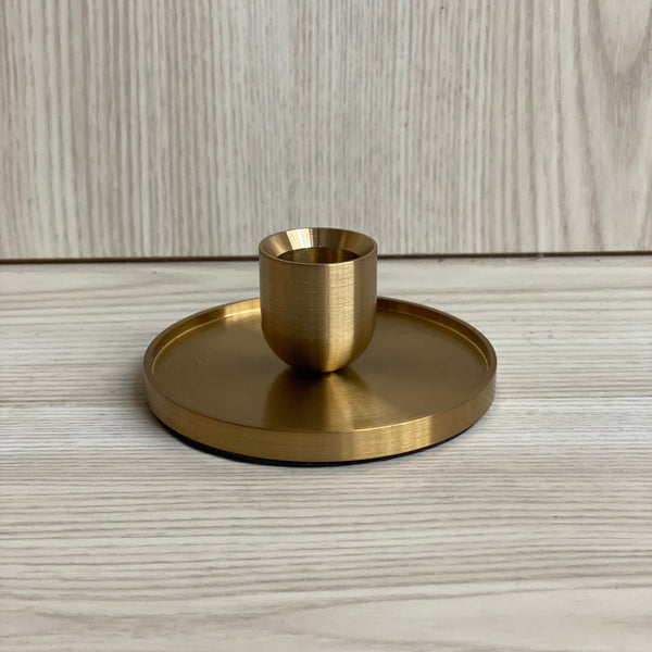 Gold Ophelia candle holder with round base and central candle cup in brushed gold finish